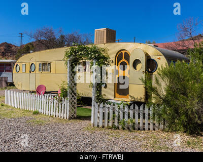 Zwei rote alten Stil Metall Rasen, die Stühle draußen ein Airfloat Flaggschiff Marke klassische Aluminium Antik gold farbigen Wohnwagen sitzen. Stockfoto