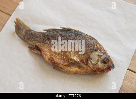 Nahaufnahme von gebratenen Fisch auf Holztisch Stockfoto