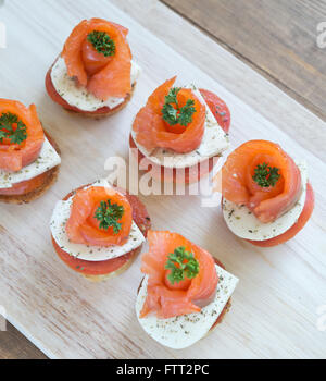 Häppchen mit Lachs und Käse auf Holzbrett Stockfoto