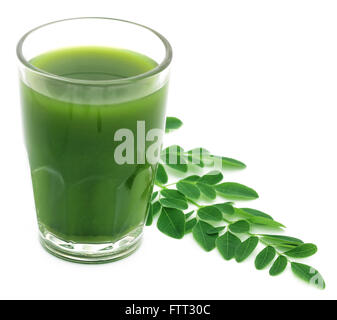 Moringa Blätter mit Saft in einem Glas auf weißem Hintergrund Stockfoto