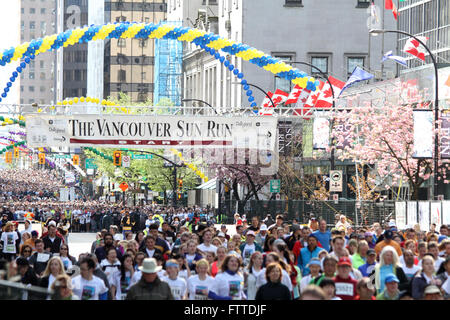 VANCOUVER, Kanada - 21. April 2013 - Läufer beim jährlichen Vancouver Sun Run lassen die Startlinie, während die nächste Welle wartet. Stockfoto