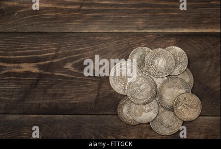 Antike Silbermünzen auf dunklem Holz Stockfoto