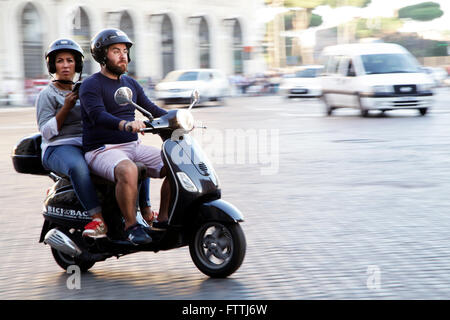 Ein paar fahren einen Vespa-Roller auf der Straße in Rom, Italien. Vespa-Roller ist eine italienische Symmbol. Stockfoto