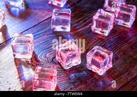 Kälte und Nässe Eiswürfel mit bunten Licht auf Holztisch Stockfoto