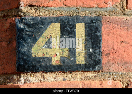 Hausnummer 41 Zeichen gemalt, Gold und schwarz auf roten Backsteinmauer Stockfoto