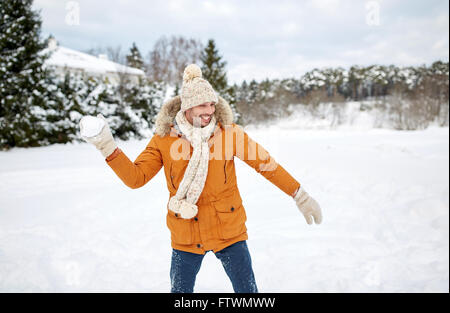 glücklich Jüngling spielen Schneebälle im winter Stockfoto