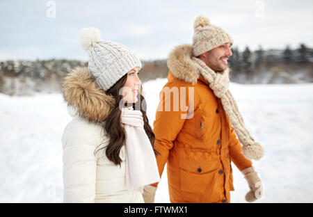 glückliches Paar zu Fuß über Winter Hintergrund Stockfoto