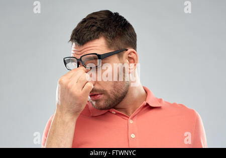 müde Mann mit Brille berühren Nasensteg Stockfoto