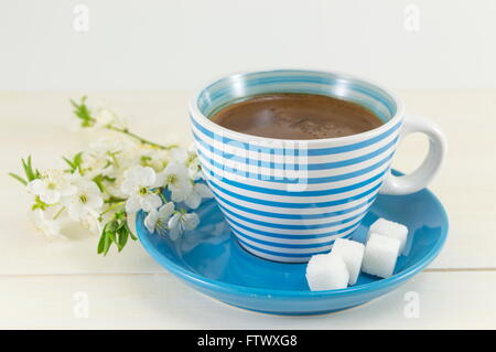 Kaffee mit Kirschblüten in einer blauen Tasse Stockfoto