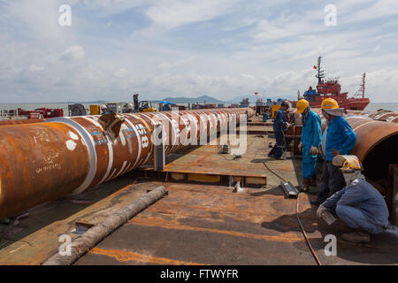 Männer, die vor einem Rig Haufen Stockfoto