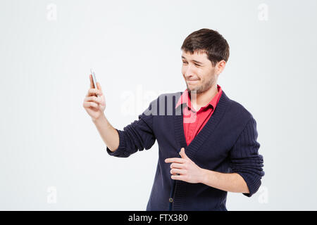 Nervöse Mann mit Smartphone isoliert auf weißem Hintergrund Stockfoto