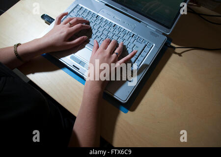 Ein Mädchen oder Damen / Frauen paar Hände Tippen auf der Tastatur eines Laptops zu Hause oder am Arbeitsplatz Stockfoto
