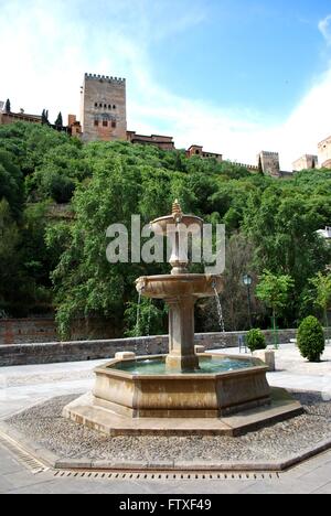 Brunnen entlang des Paseo de Los Tristes mit dem Alhambra-Palast auf der Rückseite in der Albaicin, Granada, Provinz Granada, Spanien. Stockfoto