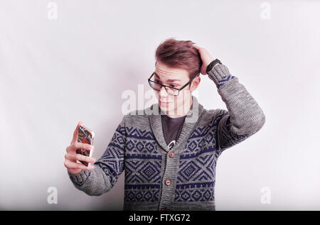 Junger Mann mit Brille, der dabei eine selfie mit einem mobilen Telefon, während mit der Hand auf den Kopf stellen. Stockfoto