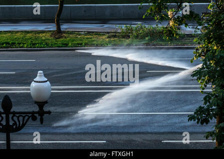 Wasserstrahlen von Sprinklern in den frühen Morgenstunden am Wasser Stockfoto