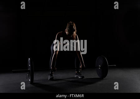 Junge Frau, die Vorbereitung auf eine Hantel heben Sie im Fitness-Studio Stockfoto