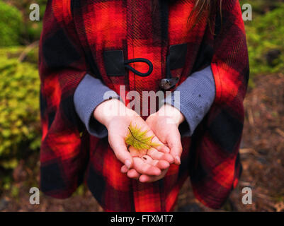 Nahaufnahme eines Mädchens hält ein Farn Blatt Stockfoto