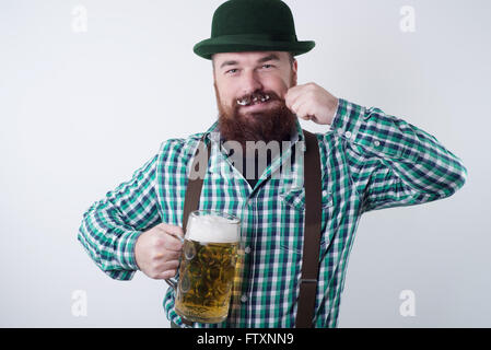 Mann hält ein Bierglas und drehte seinen Schnurrbart Stockfoto