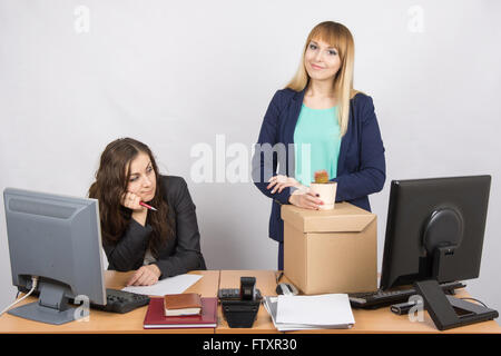 Neue Mitarbeiter im Büro hält gerne Dinge schließen traurige Kollegin Stockfoto