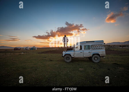 Kirgisistan, Kirgistan, Asien, einsam reisen, 4WD, Verteidiger in der Steppe bei Sonnenuntergang. Stockfoto