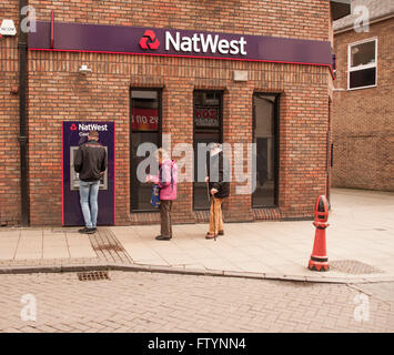 Menschen verwenden oder warten, die ATM in die National Westminster Bank in Bishop Auckland, Co Durham, England, Großbritannien Stockfoto