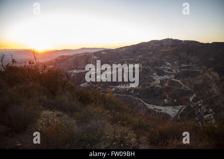 Los Angeles, Kalifornien, USA. 30. Dezember 2015. Die Sonne geht über die Lagerstätte SoCalGas Aliso Canyon blickt, wo eine undichte Gas gut und ein Relief gut gebohrt werden, an der Spitze von einem öffentlichen Wanderweg von Bee Canyon Park als Methan-Gas Leckagen an die Lagerstätte SoCalGas Aliso Canyon gut SS-25 im Stadtteil Porter Ranch in Los Angeles, Kalifornien am Mittwoch, 30. Dezember , 2015. Die Aliso Canyon-Gas-Leck (auch Porter Ranch Gasleck genannt) war eine massive Natural Gas-Leck, die am 23. Oktober 2015 begonnen. Laut Wikipedia, eine geschätzte 1.000.000 barr Stockfoto