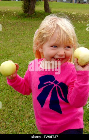 junges Mädchen pflücken Äpfel Stockfoto