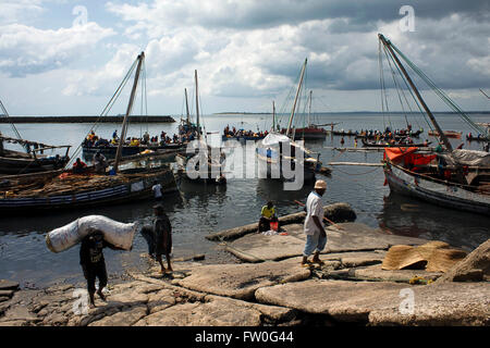 Harte Arbeiter arbeiten in der Harbur von Stone Town, entladen traditionellen Dhau in Sansibar, Tansania Stockfoto