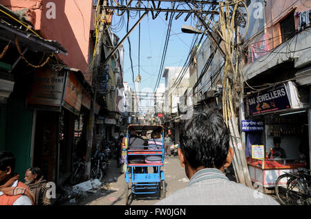 Ansicht von hinten der Fahrer auf ein Pedal Rikscha durch die Gassen von Alt-Delhi. Stockfoto