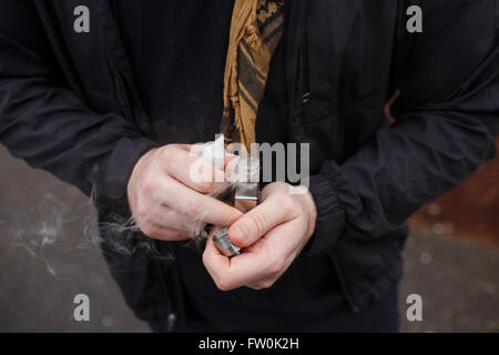 Urbaner Lifestyle Portrait von ein Mann Dampfen in einem städtischen Umfeld mit einem benutzerdefinierten Vape mod Gerät. Stockfoto