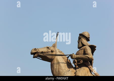 Ein schwarzer Drongo hockt auf das Schwert einer montierten Sikh Krieger-Statue an der Baba Banda Singh Bahadur-Gedenkstätte in Punjab, Indien. Stockfoto