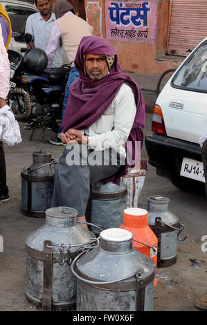 Ein Bauer sitzt wartet als Einkäufer bei der täglichen Milchmarkt in Jaipur, Rajasthan, Nordindien. Stockfoto