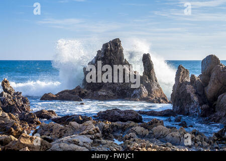 Welle am großen Felsen sonnigen blauen Himmel Stockfoto
