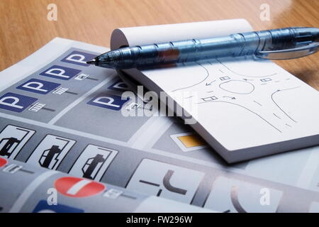 Notepad, Buch der Regeln, Spielzeugautos, Ampeln und Zeichen auf einem Schreibtisch Tisch Anschlag. Studium und der Vorbereitung auf die Fahrprüfung Stockfoto