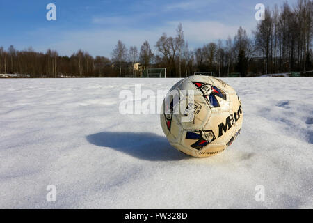 worn-out Fußball auf Schnee Stockfoto