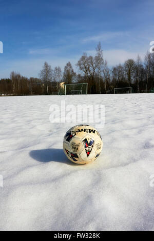 worn-out Fußball auf Schnee Stockfoto