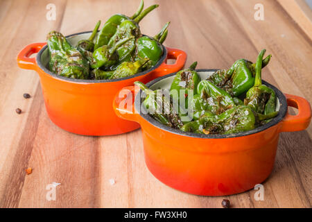 Padron gegrillte Paprika mit Salz und Pfeffer in kleinen Gusseisen Töpfe Stockfoto