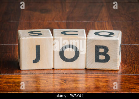 Würfel mit dem Wort Job auf einem dunklen Holztisch Stockfoto