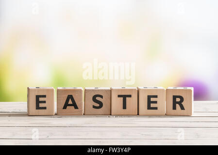 Ostern-Schild an einem Holztisch im Garten Stockfoto