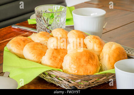 Frühstück auf einer Tabelle mit Brötchen im Korb Stockfoto