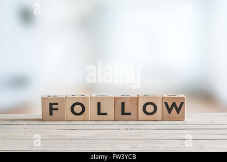 Folgen Sie Zeichen der Würfel auf einem Holztisch Stockfoto