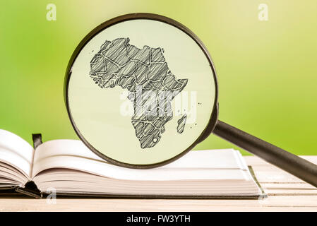 Afrika-Informationen mit einer Bleistiftzeichnung einer afrikanischen Karte in eine Lupe Stockfoto