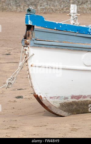 Ein altes Fischerboot vor Anker am Strand bei Ebbe Stockfoto