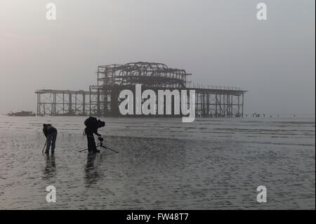 Zwei Fotografen an Brightons verlassenen Pier West, Ebbe, nebligen Morgen Stockfoto