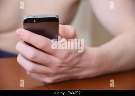 Teenage Boy unter Verwendung eines Apple 5 s iPhone Handy Stockfoto