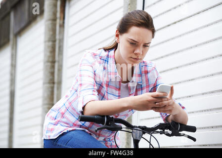 Teenager-Mädchen auf Bike-SMS auf dem Handy Stockfoto