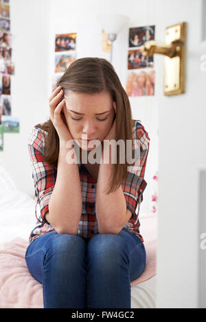 Depressive Teenager-Mädchen sitzen im Schlafzimmer Stockfoto