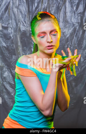Junge Frau mit bunten Make up Gummibärchen Gelee Würmer Bonbons in Händen hält. Stockfoto