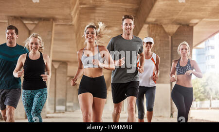 Diverse Erwachsene Training mit laufenden Club-Gruppe. Glückliche junge Menschen zusammen in die Stadt laufen. Stockfoto