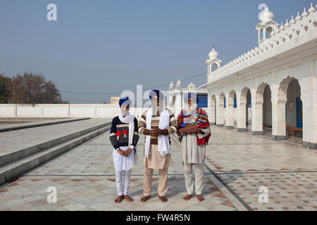 Eine junge männliche Sikh mit zwei Sikh Missionare im Gurdwara Sri Gangtsar, Chattiana im indischen Bundesstaat Punjab. Stockfoto